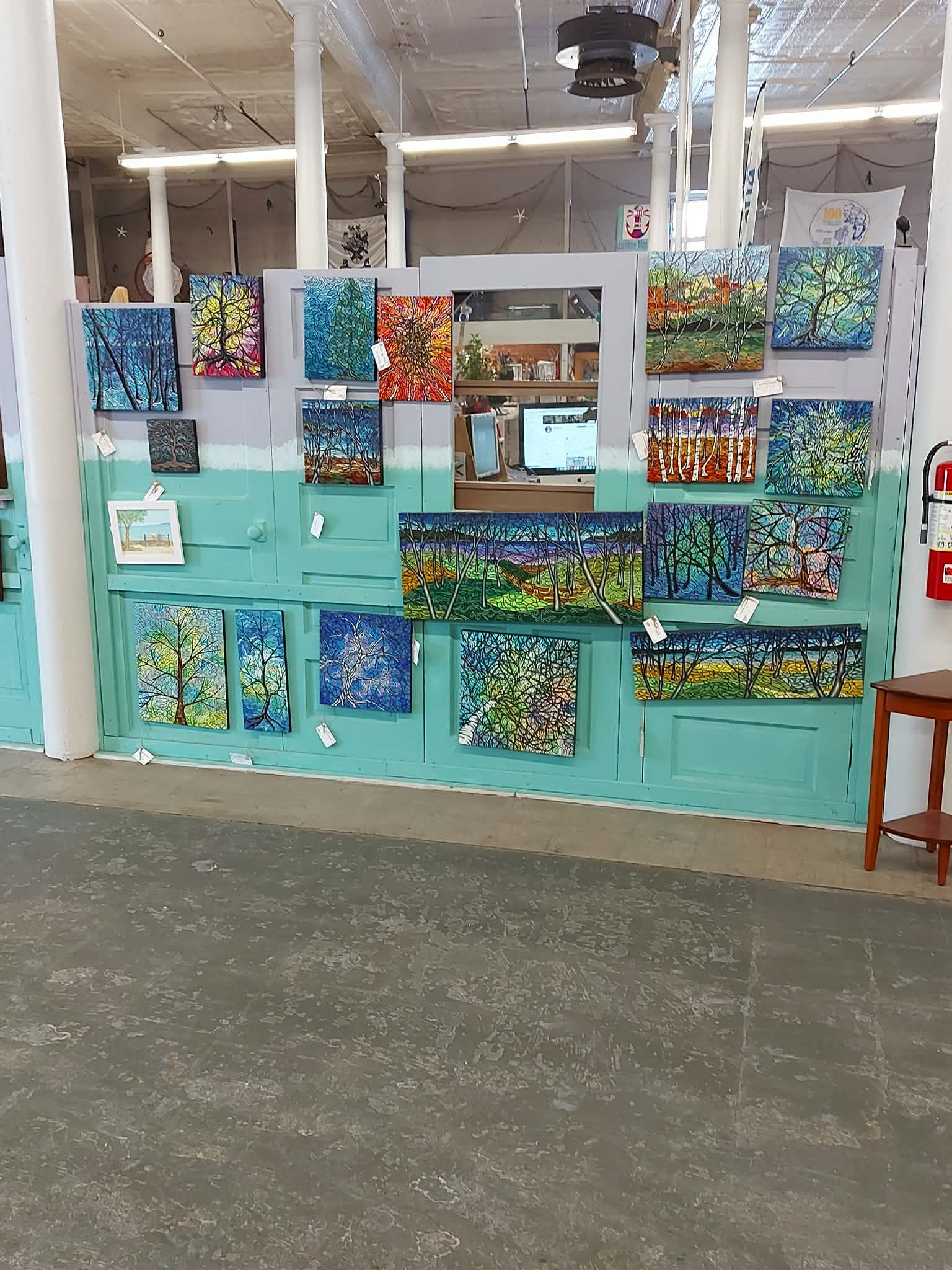 Full wall display of Anne Borbey-Schwartz original paintings at Maritime Mosaic